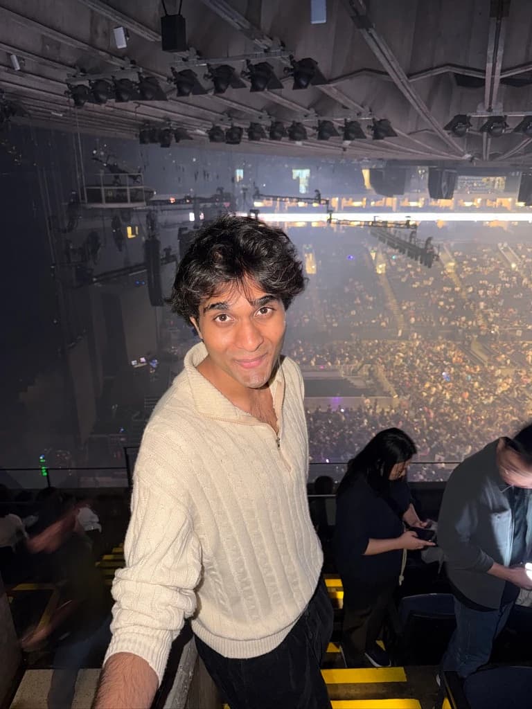 Me in a cream sweater overlooking a concert crowd.